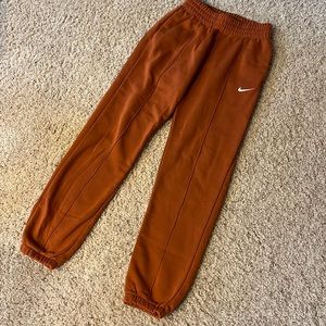 nike woman’s fleece sweatpants: burnt sunrise in size XS